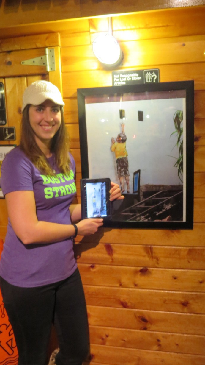 At Penang restaurant, holding my own photo of street art taken in Penang, Malaysia next to identical photo on the wall.